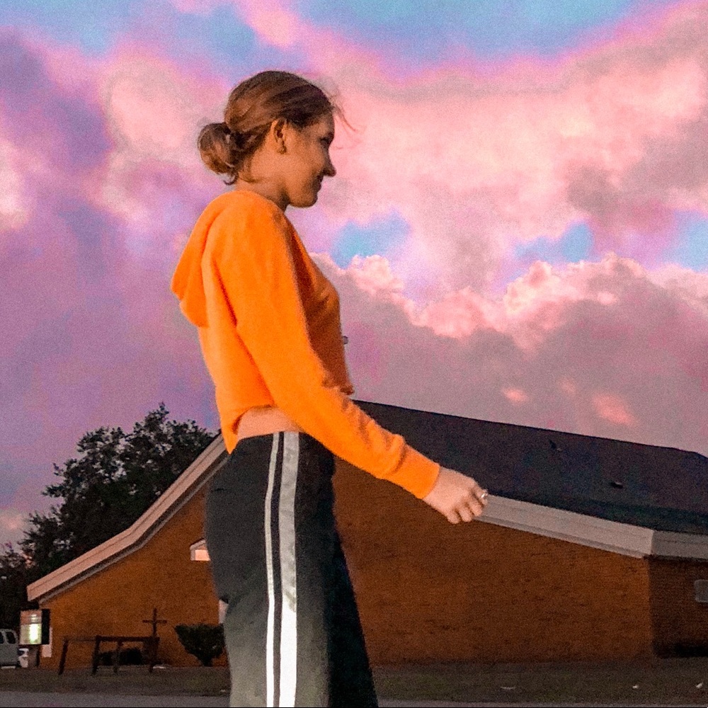 Cropped neon orange hoodie.
